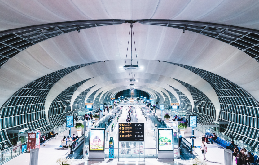 Modern airport terminal with moving walkways and digital signage, illustrating a contactless, streamlined passenger journey