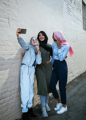 Three woman taking a group selfie using a phone